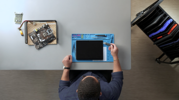 Pogled iz ptičje perspektive na tehničara koji popravlja Surface uređaj